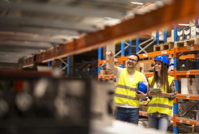Warehouse workers checking inventory in large distribution warehouse storage.