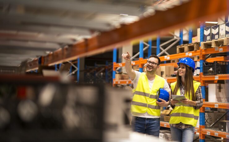 Warehouse workers checking inventory in large distribution warehouse storage.